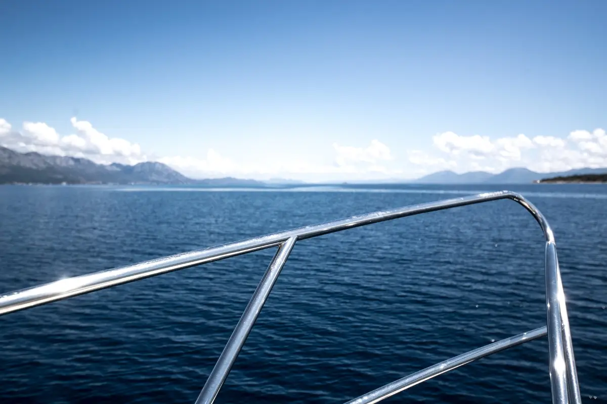 Étrave d'un bateau face à une côte calme